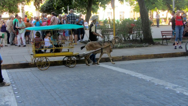 Outside the theater, kids in cart by plaza. Cobblestone street