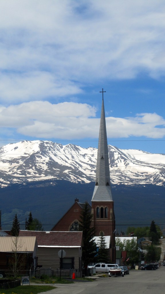 Annunciation Catholic Church with snow capped mountains