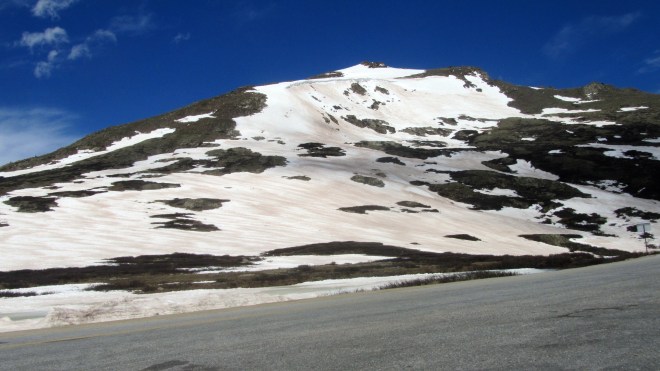Windswept mountain top with summer snow
