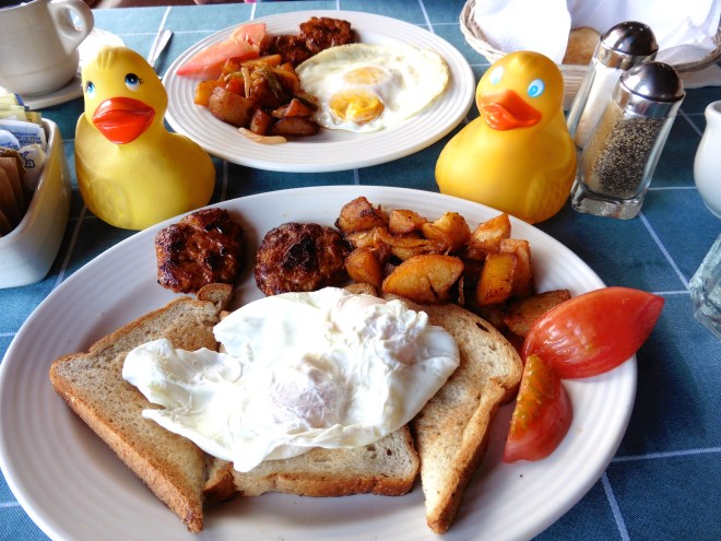 Eggs, toast, homemade sausage and artistically cut tomatoes