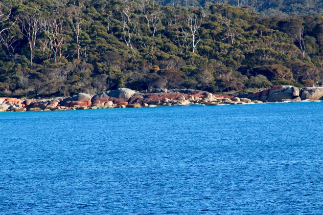 Bright blue water and orange rocks lining the bay