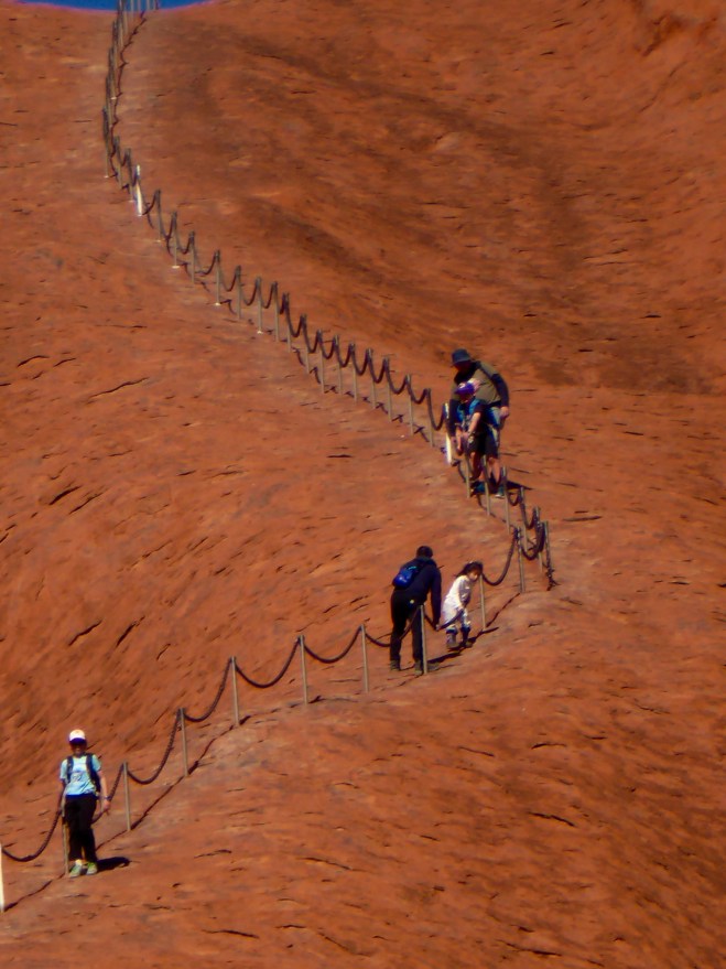Some tourists climb Uluru