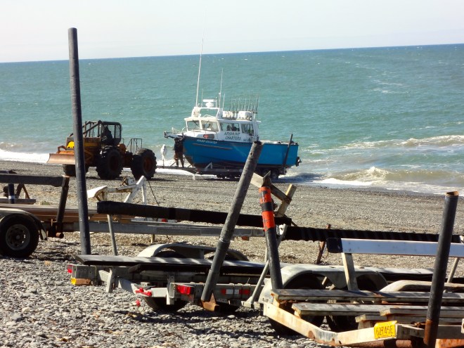 Truck pulls trailer with boat out of water and they go home.