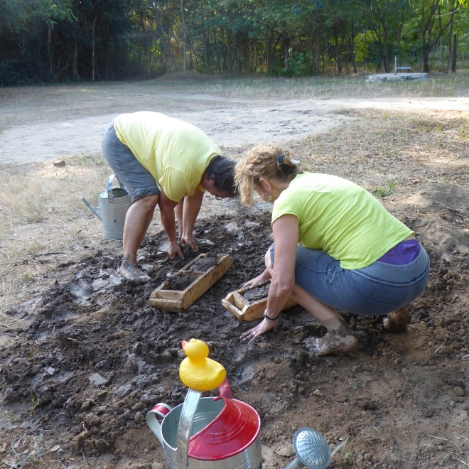 Barefoot in the mud. Filling brick molds with mud for bricks
