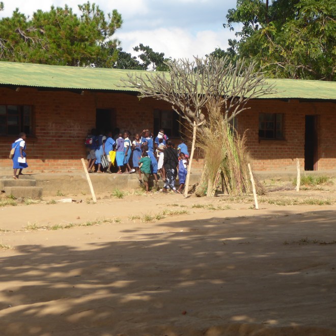 Children in uniforms entering school