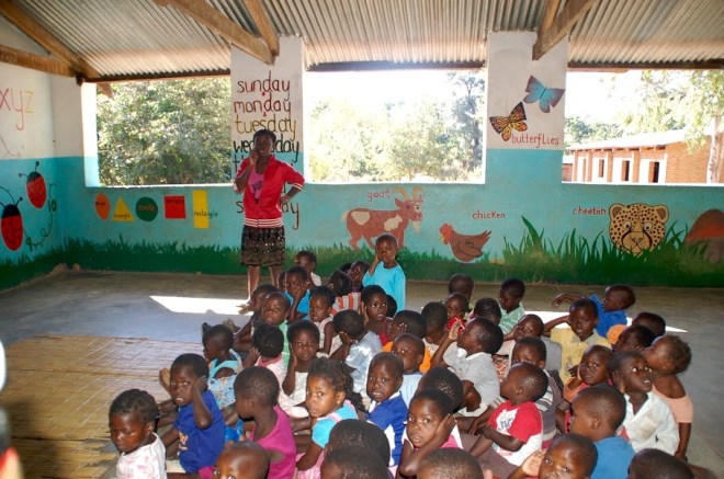 Attentive students on floor. No desks and chairs available