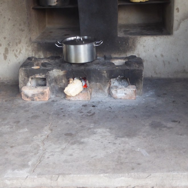 Esther cooks on a three burner wood burning changu changu moto