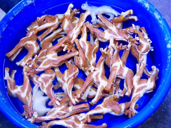 Newly made giraffe candles cooling in cold water