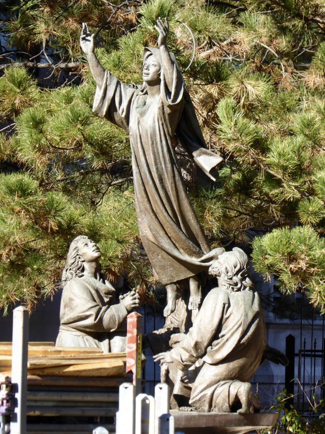 Statues in the garden. Through renovation fence