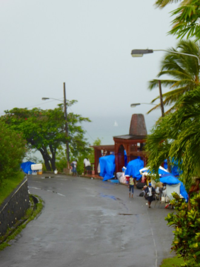 Vendors protecting merchandise while raining.